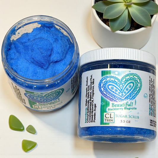 Two jars of blue sugar scrub with visible brand labels on a white surface.