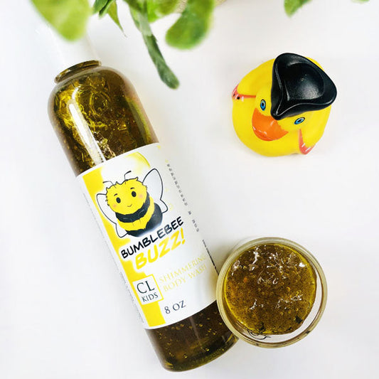 Bumblebee Buzz Shimmering Body Wash in a transparent bottle and cup of our golden yellow bumblebee buzz body wash against a white background