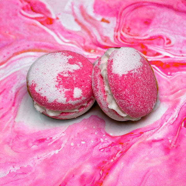 Two pink and white bunny tracks bath cookies against a pink and white watery background