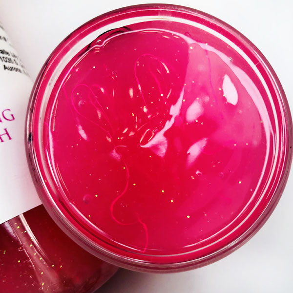 Piggy Snorts Shimmering Body Washi in a cup of our pink piggy snorts body wash against a white background