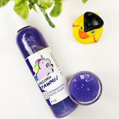 Unicorn Yawns Shimmering Body Wash in a  transparent bottle and cup of our purple unicorn yawns body wash against a white background